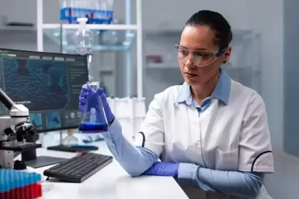 Uma biomédica realiza ensaios no laboratório.